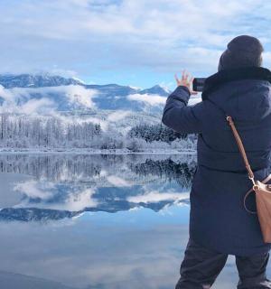 一位女士正在拍摄湖景