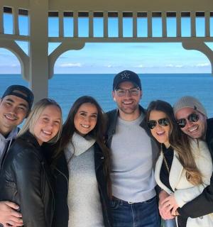 a group of people posing for a picture in front of the ocean