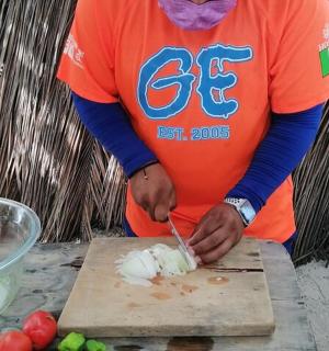 a person cutting up food on a cutting board