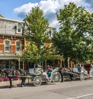 a horse drawn carriage parked in front of a house