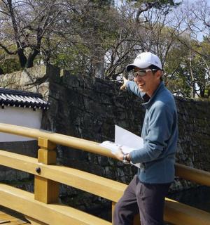 a man standing on a bridge talking on a cell phone