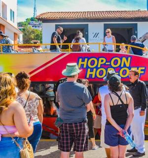 a group of people standing in front of a double decker bus