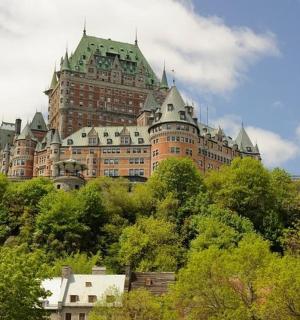 a large building on top of a hill with trees