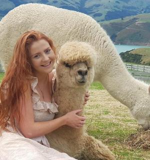 a woman in a wedding dress holding a sheep