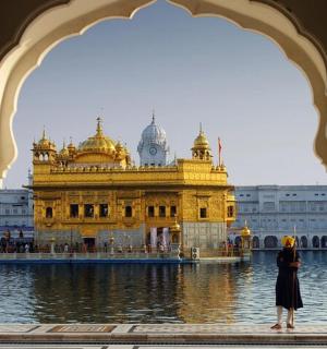 a woman standing in front of a golden temple