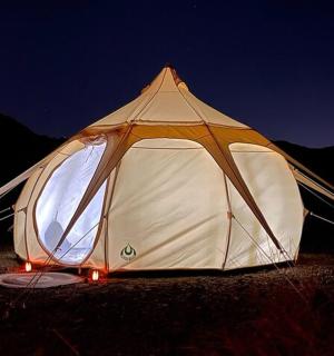 bílý stan se světly na poli v noci