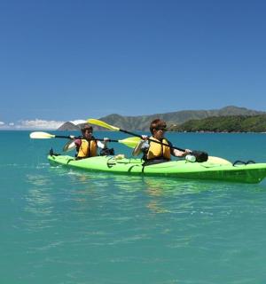 two people in a green kayak in the water