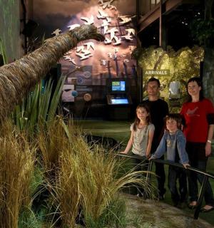 rodina stojící před expozicí dinosaurů