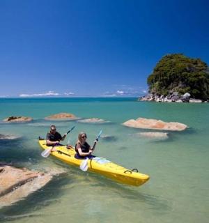 两个人在水中的黄色皮划艇上