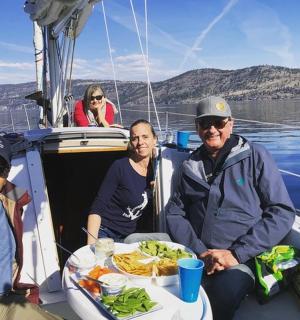 一群人坐在船上,面前摆着一盘食物