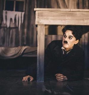 a painting of a man hiding under a table