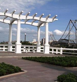 a large white pavilion with a bridge in the background