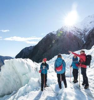 a group of people standing on a glacier in the snow
