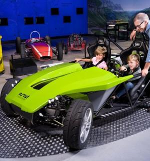 muž a dvě děti v zeleném autě