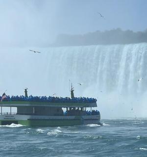 loď ve vodě poblíž vodopádu