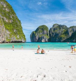 skupina lidí na pláži s vápencovými útesy