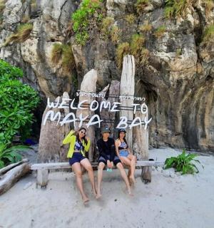 三个女人坐在海滩的长椅上