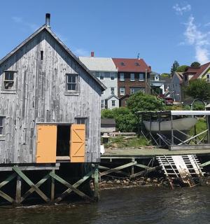 an old house sitting on a dock in the water