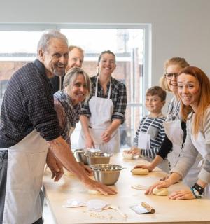 a group of people standing around a table in a kitchen