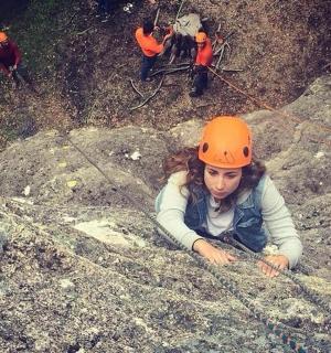 moteris su oranžiniu šalmu guli ant uolų