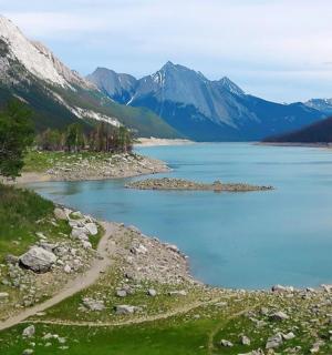 ein großes Gewässer mit Bergen im Hintergrund