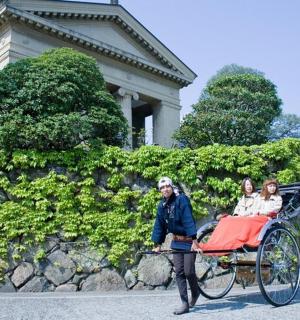 一名男子拉着一辆载有两个人的马车