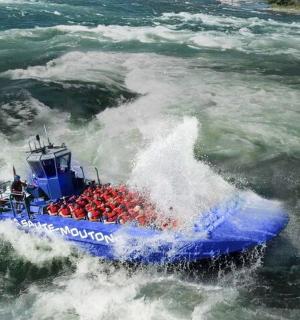 a blue boat in a wave in the water