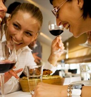 skupina tří žen, které se smějí při pití vína