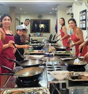 a group of people standing in a kitchen preparing food