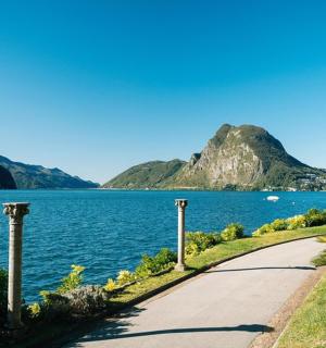 silnice vedle vodní plochy s horou