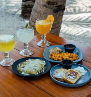 a table with plates of food and two glasses of orange juice