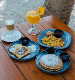 a wooden table with plates of breakfast food and a glass of orange juice