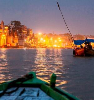 Loď ve vodě v noci s městem