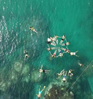 an aerial view of people in the water at a beach