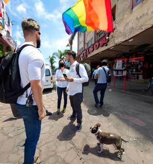 un grup de oameni care merg pe stradă cu un câine
