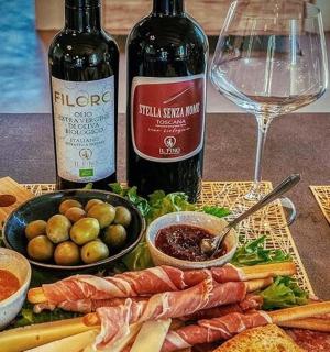 a table with two bottles of wine and a plate of food