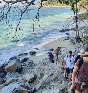 a group of people walking along a rocky beach