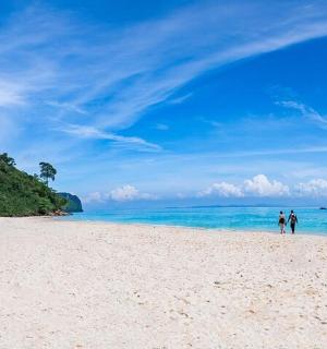 to personer går på en strand nær havet