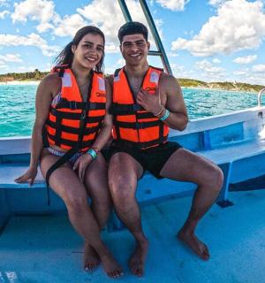 穿着救生衣的男人和女人坐在船上