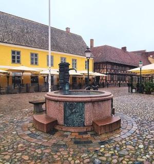 ein Brunnen in der Mitte eines Hofes mit Gebäuden