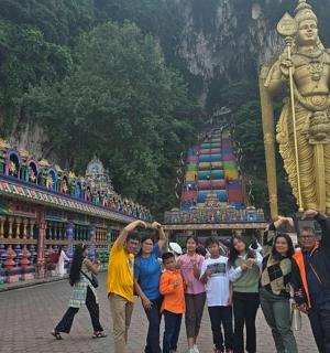 skupina lidí stojících před sochou