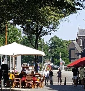 a group of people sitting at tables and umbrellas