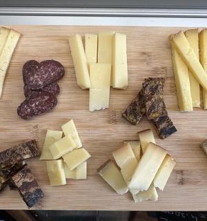 一块砧板,上面放着不同类型的奶酪和葡萄