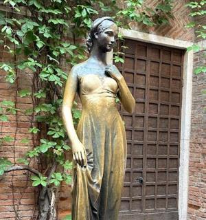 一座站在建筑物前的女人雕像