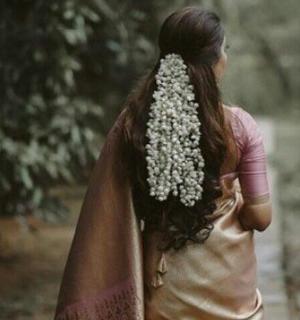 a woman is walking down a sidewalk with her hair in a braid