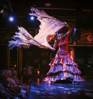 a woman in a dress on a stage with a fan