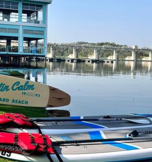 Dva kajaky sedí na trávě vedle lodi