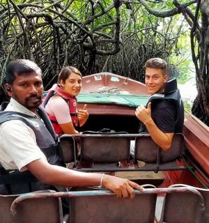 a group of people riding in a boat in the jungle