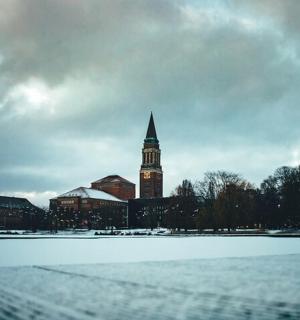 一座带有钟楼的建筑，旁边是一片白雪覆盖的田野