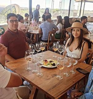 一群人坐在桌边,手里拿着酒杯